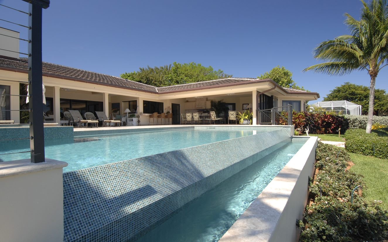 a pool with a large deck and a house